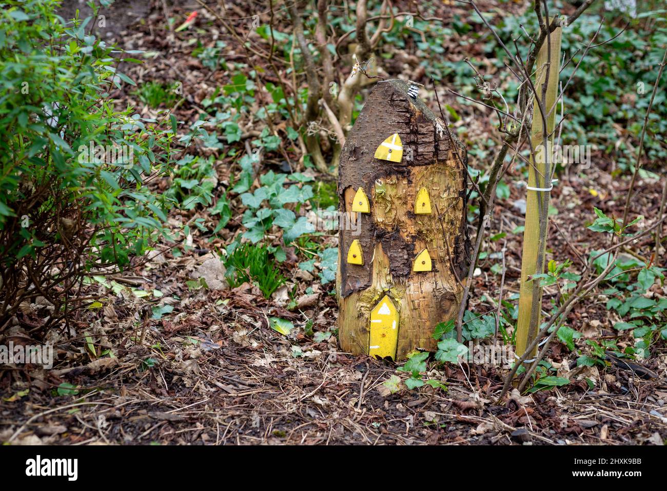 Grande maison de fées en bois avec fenêtres jaunes et porte de fées