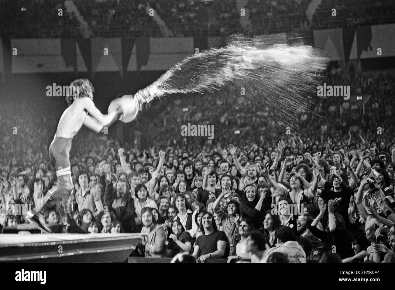 Mick Jagger jette de l'eau sur la foule lors d'un spectacle de Rolling Stones à Earls court Arena, Londres, Angleterre. Mick Jagger. 22nd mai 1976. Banque D'Images