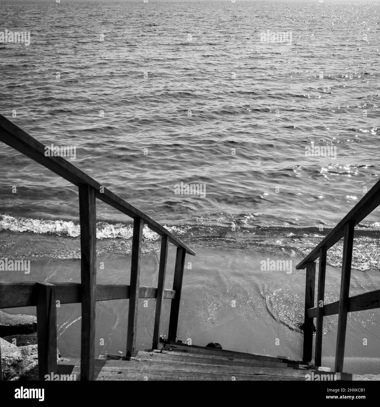 Mer et escaliers escarpés vers la plage. Photographie en noir et blanc Banque D'Images