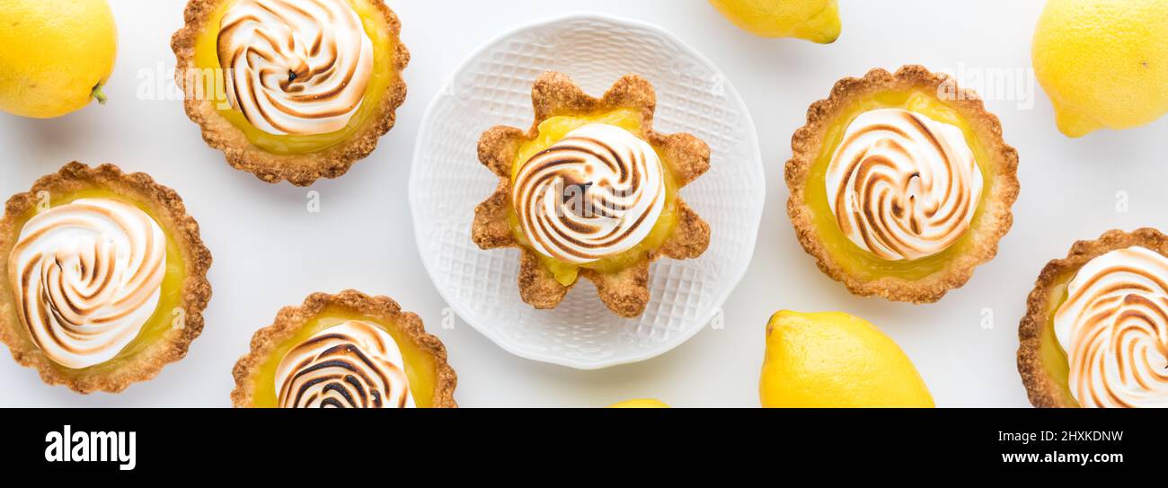 Une vue étroite sur les citrons et les tartelettes de meringue au citron avec une sur une assiette de service. Banque D'Images