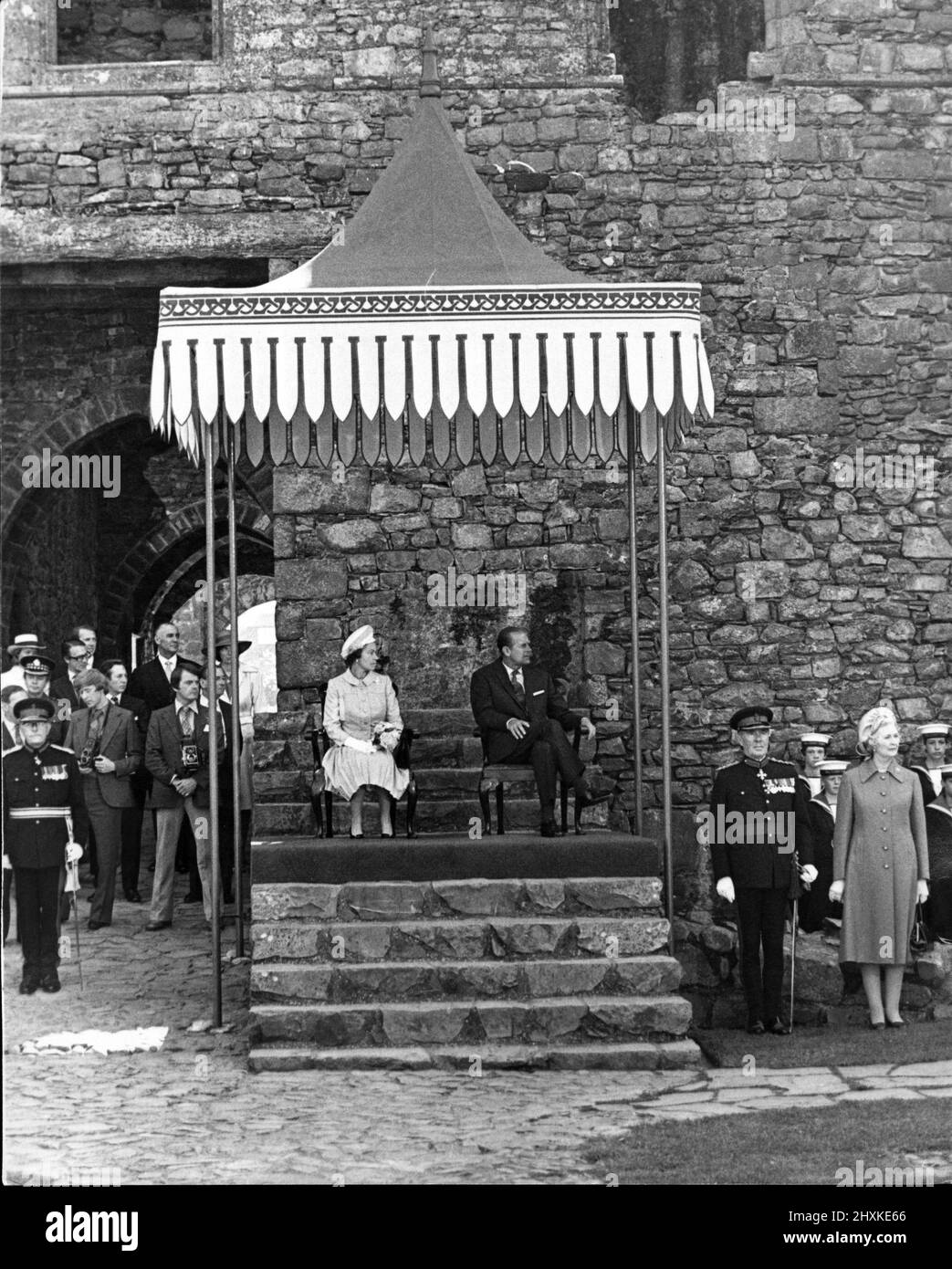 La reine Elizabeth II et le duc d'Édimbourg s'assoient à l'ombre et profitent des débats au château de Harlech, à Llandudno. WalesThe Queen est en tournée du Jubilé d'argent au pays de Galles. 1977. La Reine portait un haut bleu clair et une jupe et un chapeau blanc. Photo prise le 22nd juin 1977. Banque D'Images