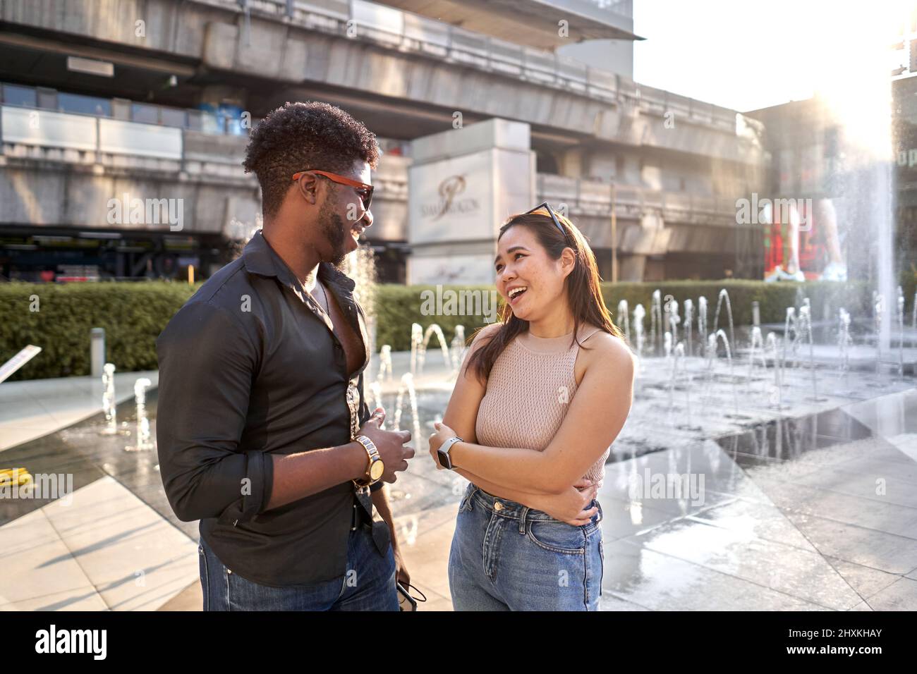 Deux amis d'origines ethniques différentes discutant dans un centre commercial Banque D'Images