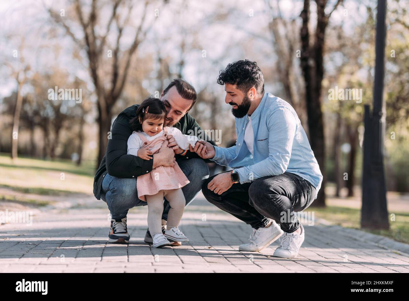 Couple gay masculin jouant avec leur fille dans le parc. Concept de famille moderne. Banque D'Images