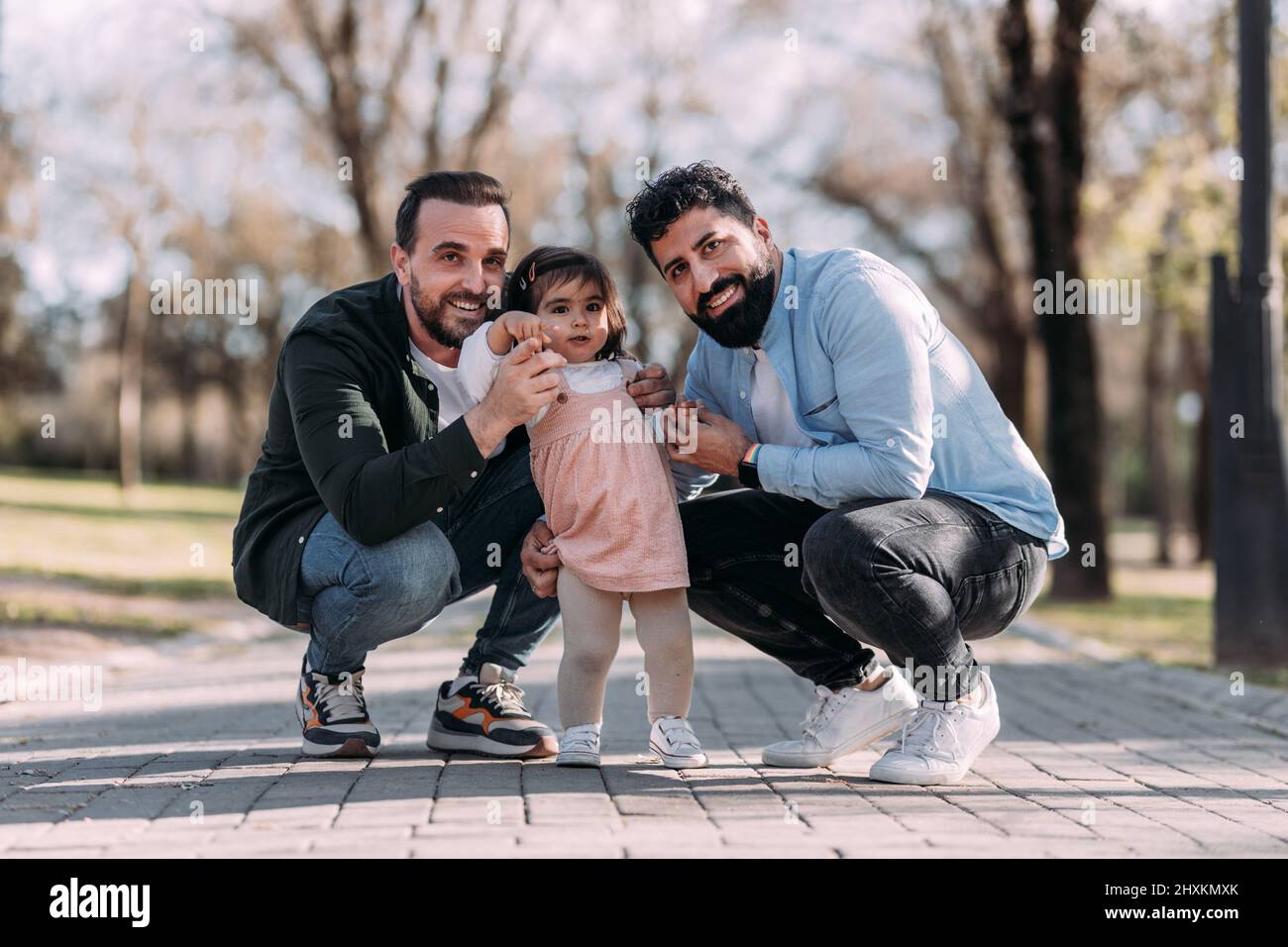 Portrait d'un couple gay masculin appréciant avec leur fille dans le parc. Concept d'adoption. Banque D'Images