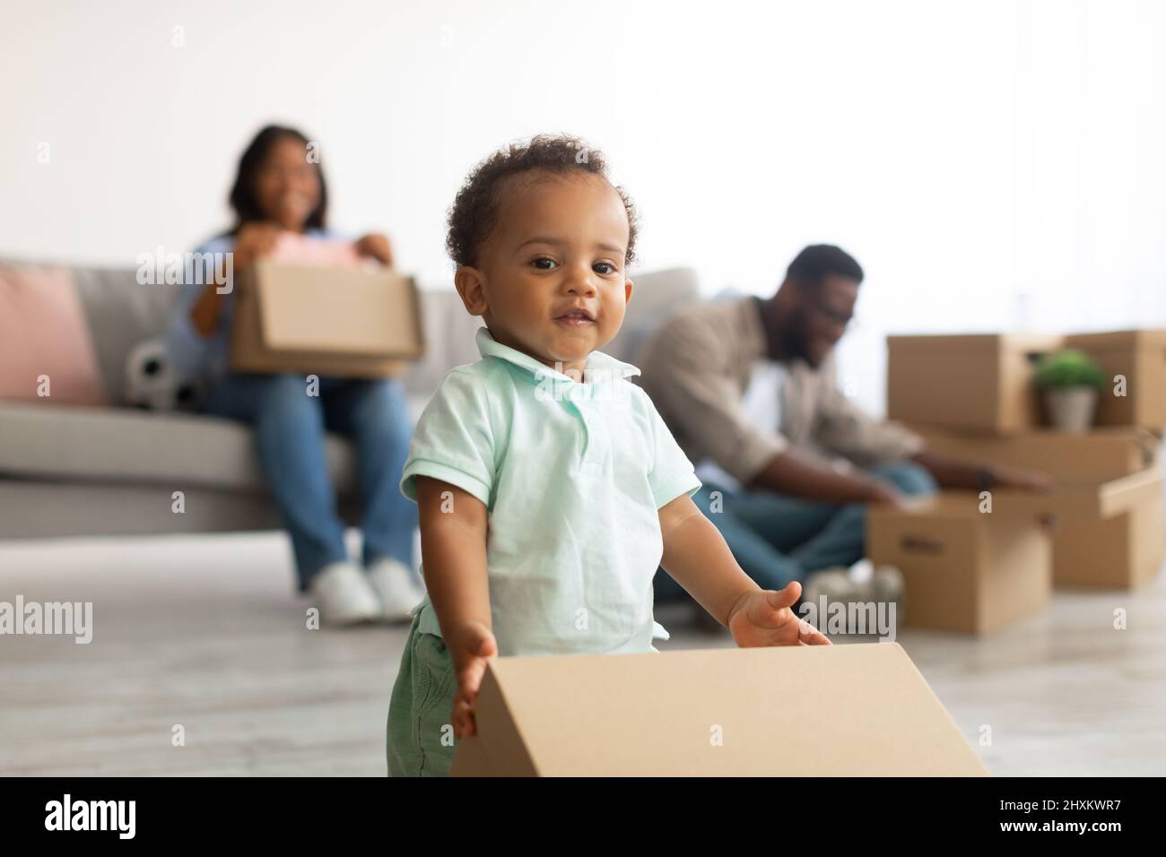 Bonne famille noire déménageant dans un nouvel appartement Banque D'Images