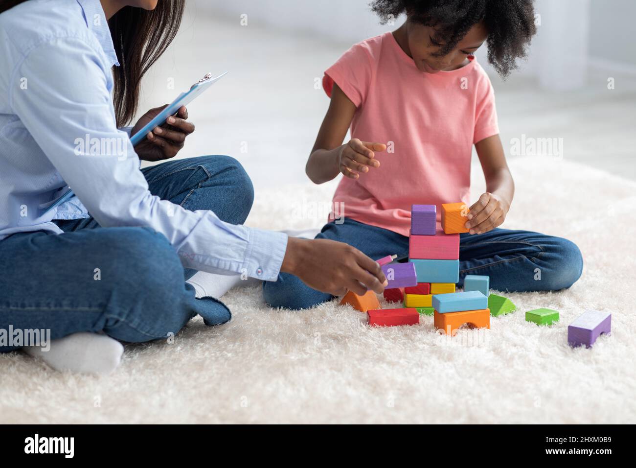 Culture de psychothérapeute enfant et enfant jouant avec des briques Banque D'Images