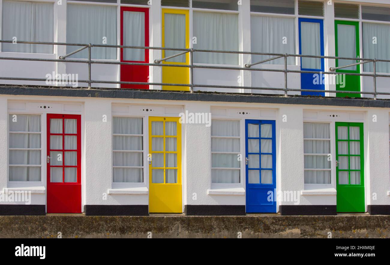 Les portes de couleur primaire des chalets ou des cabanes de plage donnent sur la plage de Porthgwidden à St Ives, Cornwall, Royaume-Uni. Banque D'Images