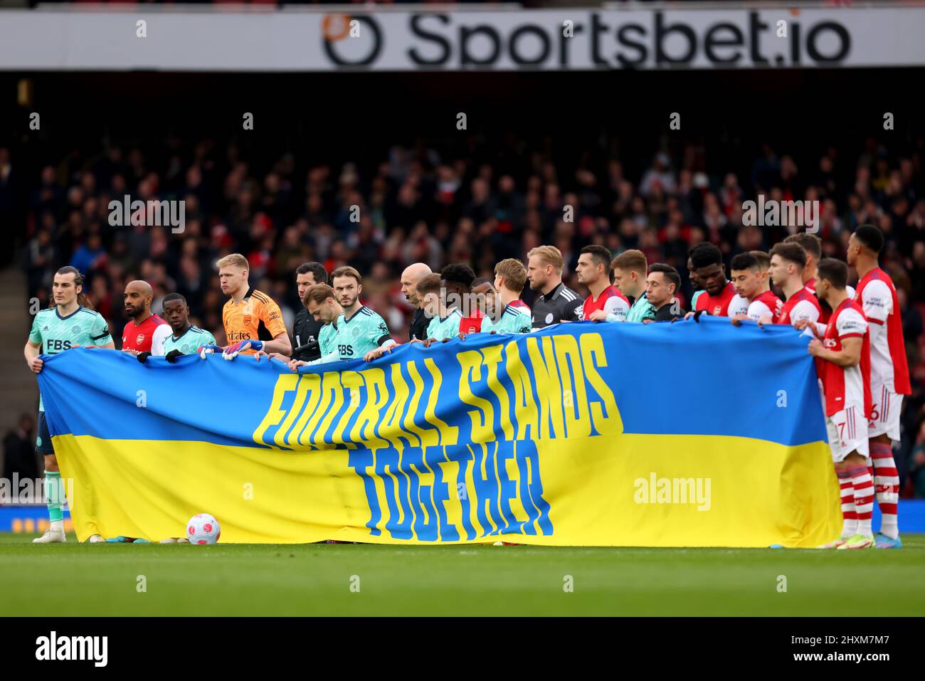 13th mars 2022 ; The Emirates, Islington, Londres, Angleterre. Football de première ligue, Arsenal contre Leicester City : les deux équipes se tiennent derrière une bannière soutenant l'Ukraine disant que football se tient ensemble Banque D'Images