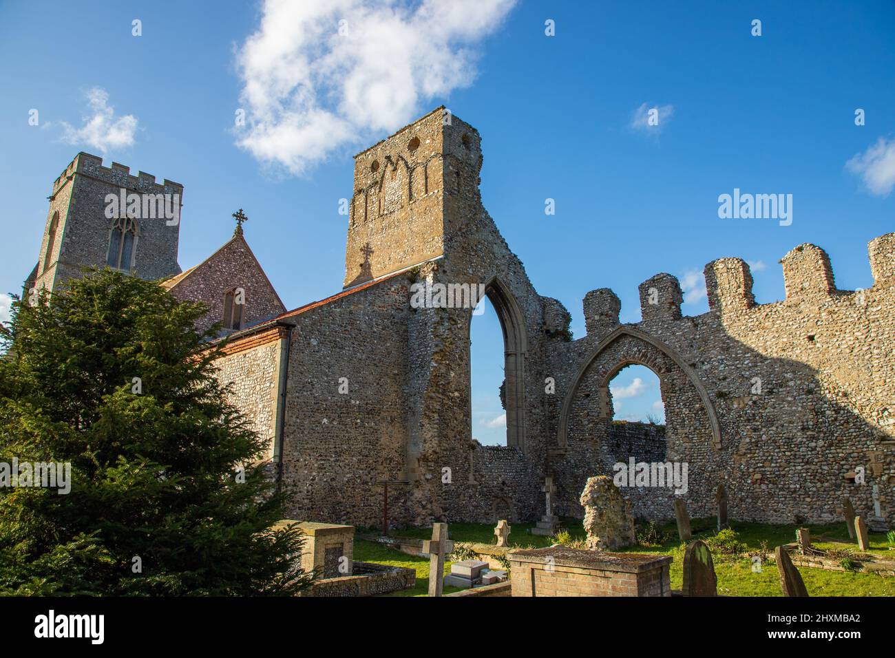 Vue latérale arrière de l'église et des ruines du Prieuré de l'église de Weybourne dans le nord de Norfolk au Royaume-Uni, par un beau ciel bleu Banque D'Images