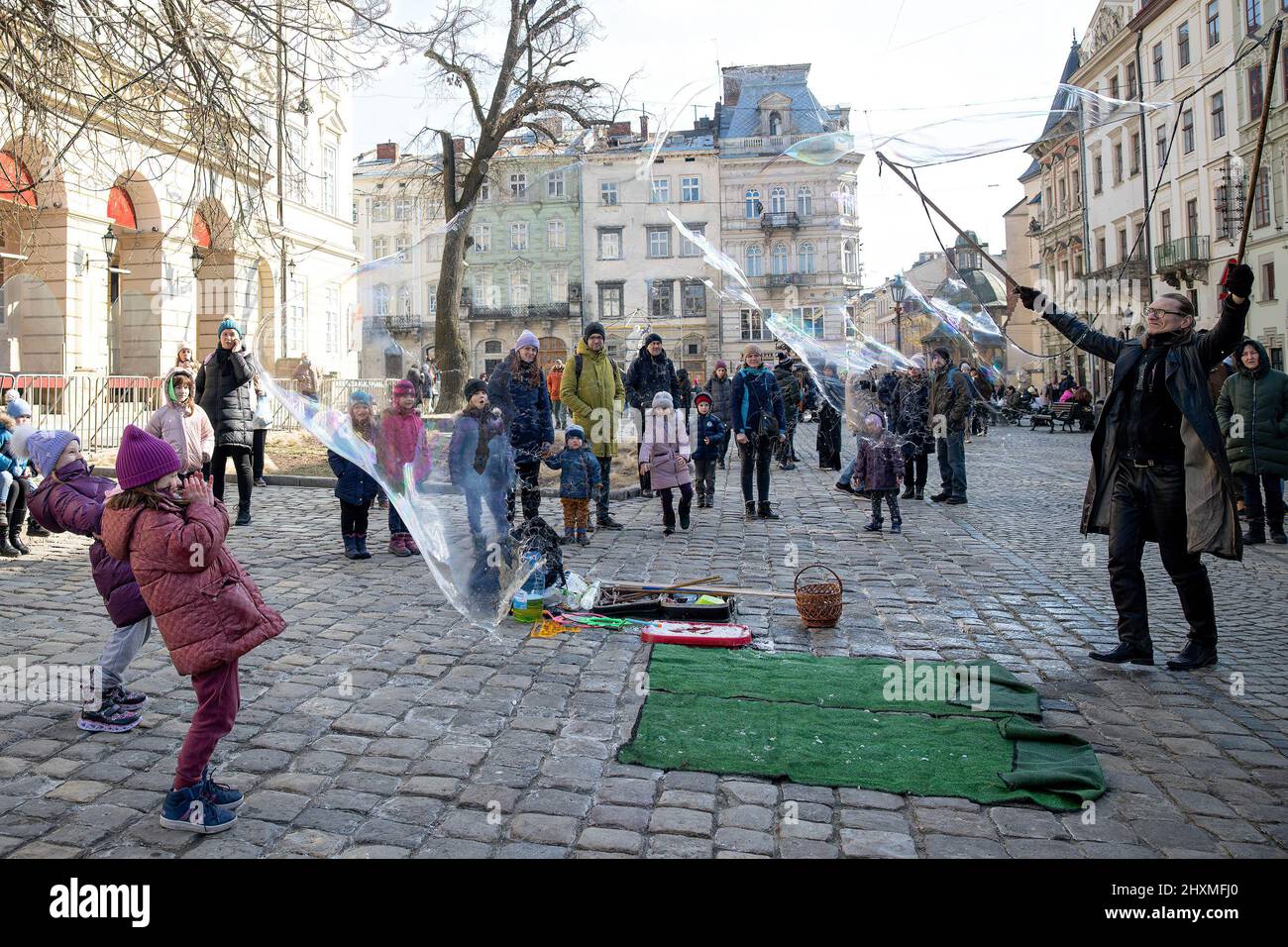 Lviv, Ukraine. 13th mars 2022. Les enfants jouent avec des bulles de savon au centre-ville de Lviv. Les civils de Lviv tentent de vivre leur vie quotidienne malgré cet attentat à la bombe russe perpétré ce matin sur une base militaire à l'extérieur de Lviv. (Image de crédit : © Hesther ng/SOPA Images via ZUMA Press Wire) Banque D'Images