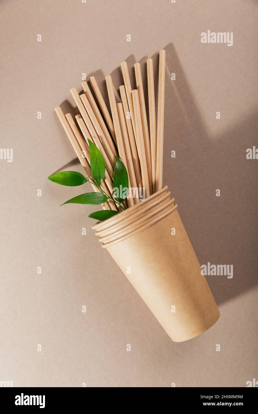 Vaisselle en papier jetable. Tasses et pailles sur fond beige. Concept sans plastique et sans déchets. Banque D'Images