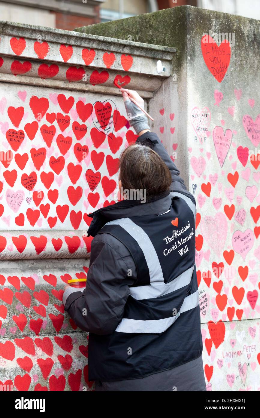 Un volontaire de Covid 19 familles Bereaved pour Justice repeint le mur Covid avec la peinture de maçonnerie appropriée, afin que les gens puissent laisser des dedi permanents Banque D'Images