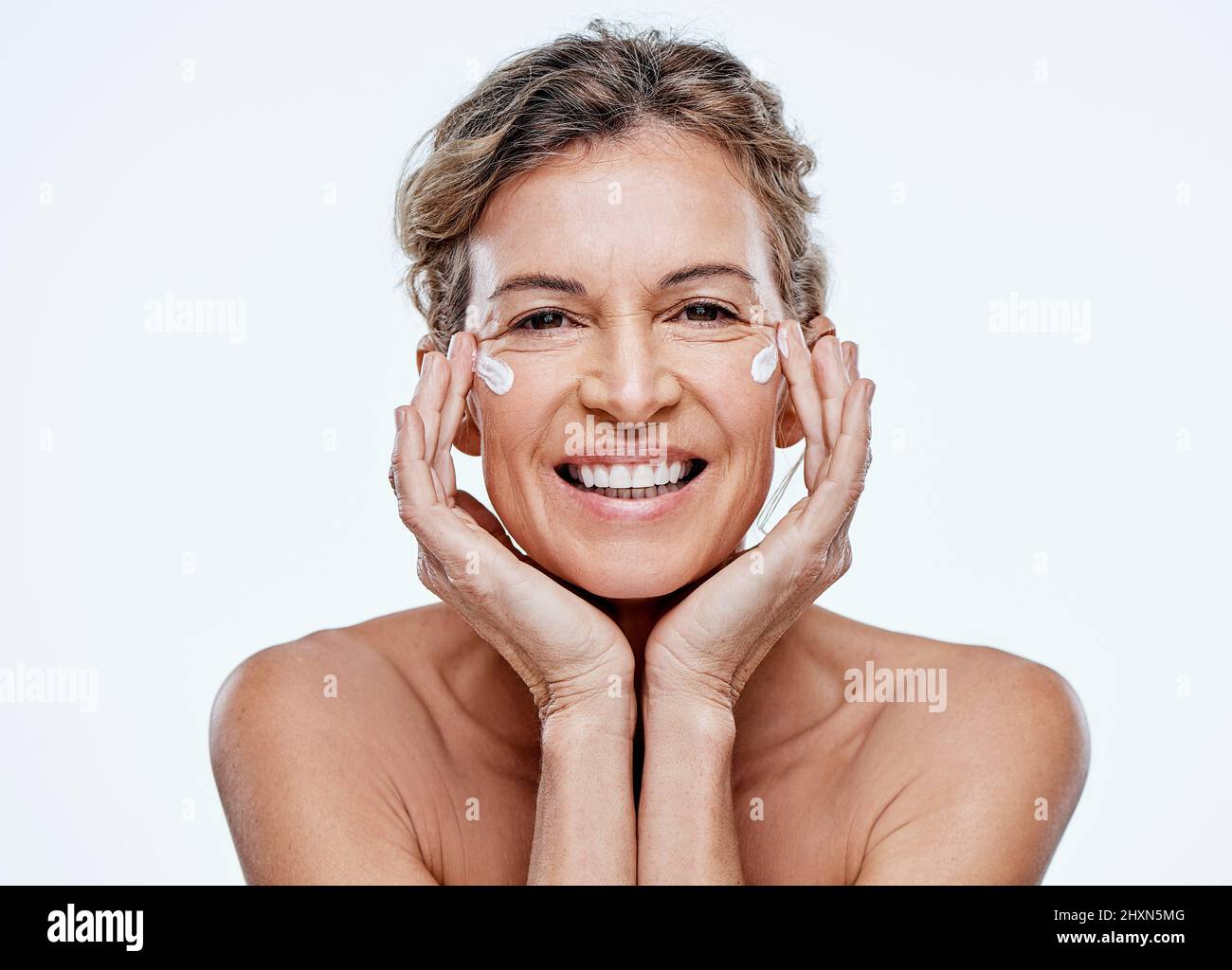 Un bon hydratant fera la plupart du travail pour vous. Plan d'une femme mûre posant avec un hydratant sur son visage. Banque D'Images
