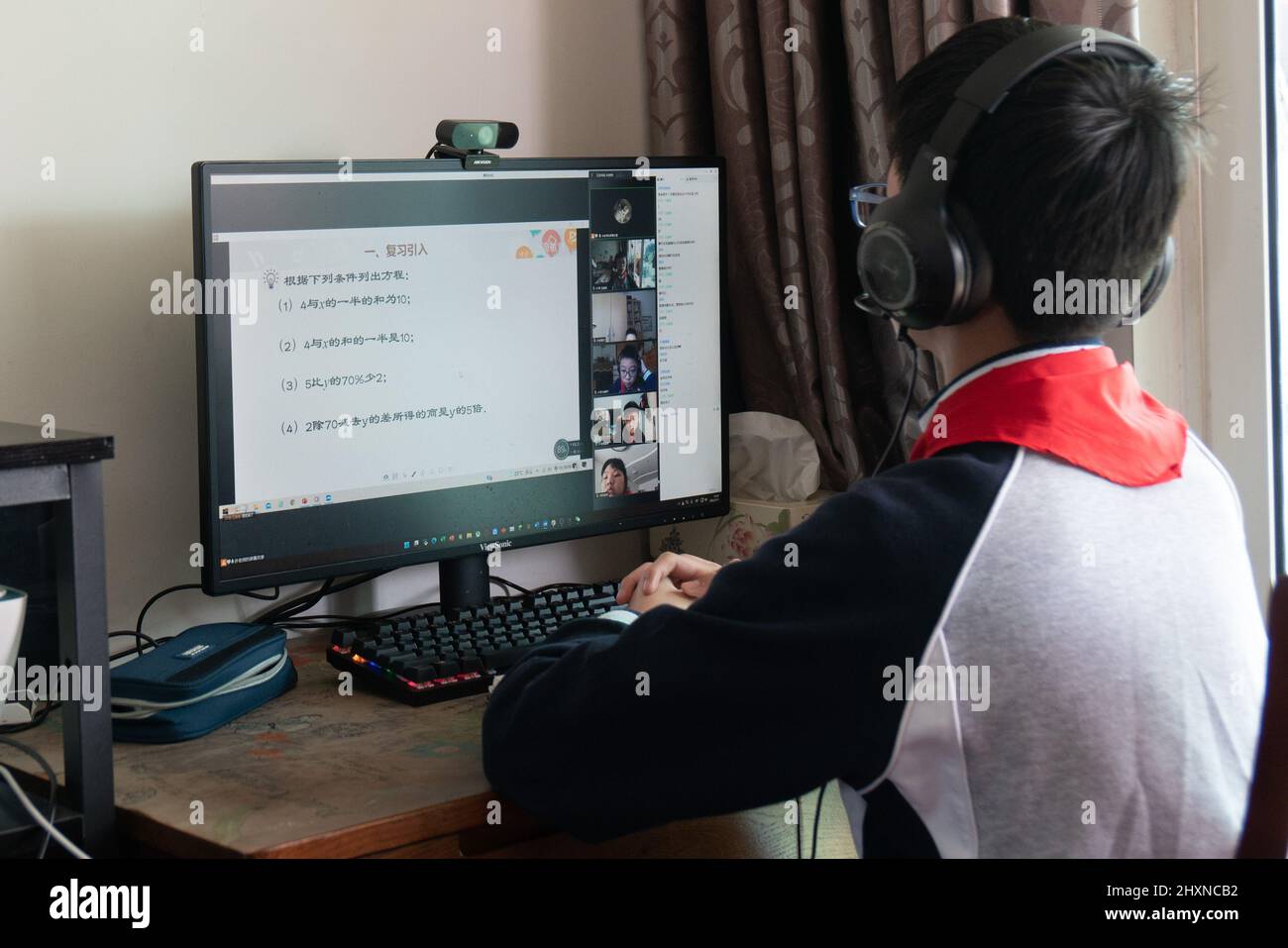 SHANGHAI, CHINE - 14 MARS 2022 - Un étudiant de lycée junior étudie devant un ordinateur à la maison pendant un cours de maths matinal à Shanghai, en Chine, Banque D'Images