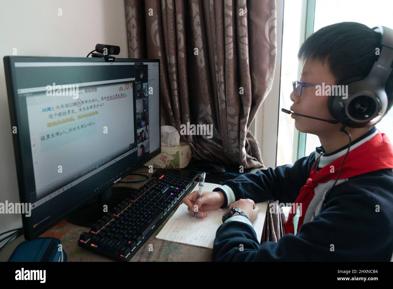 SHANGHAI, CHINE - 14 MARS 2022 - Un étudiant de lycée junior étudie devant un ordinateur à la maison pendant un cours de maths matinal à Shanghai, en Chine, Banque D'Images