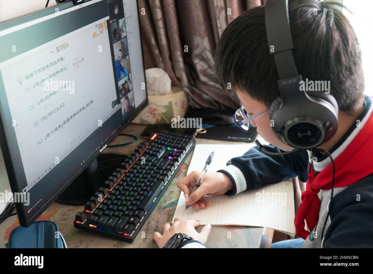 SHANGHAI, CHINE - 14 MARS 2022 - Un étudiant de lycée junior étudie devant un ordinateur à la maison pendant un cours de maths matinal à Shanghai, en Chine, Banque D'Images