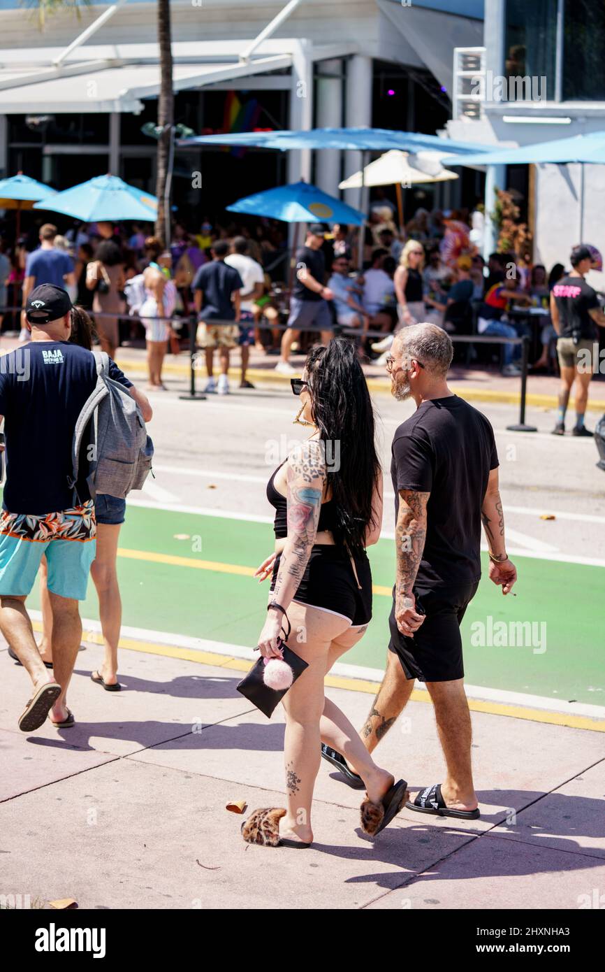 Miami Beach, FL, États-Unis - 12 mars 2022 : couple avec de nombreux tatouages marchant le long de l'océan Drive Spring Break Banque D'Images