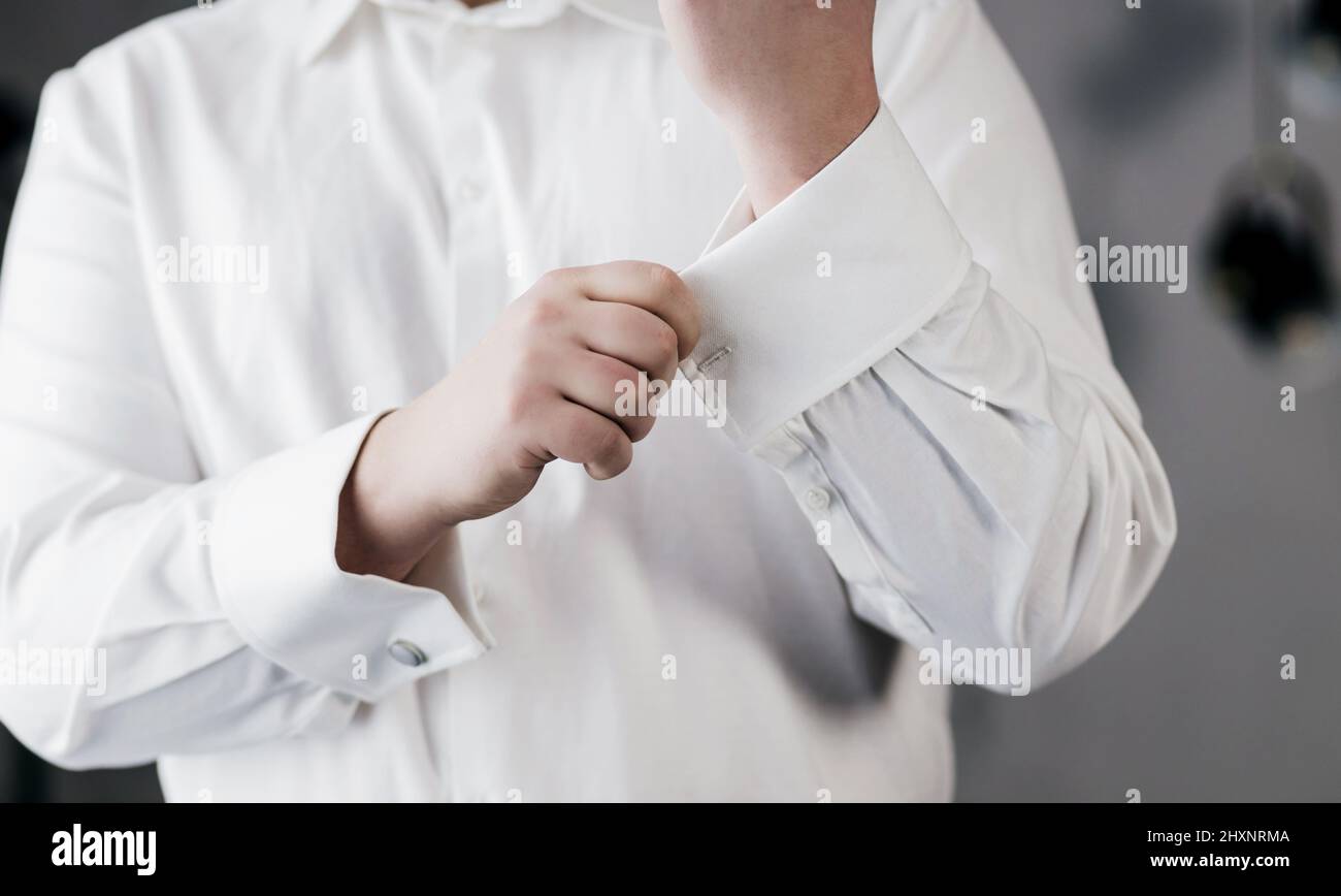 homme élégant dans une chemise blanche est fesses boutons de manchette.  bijoux Photo Stock - Alamy