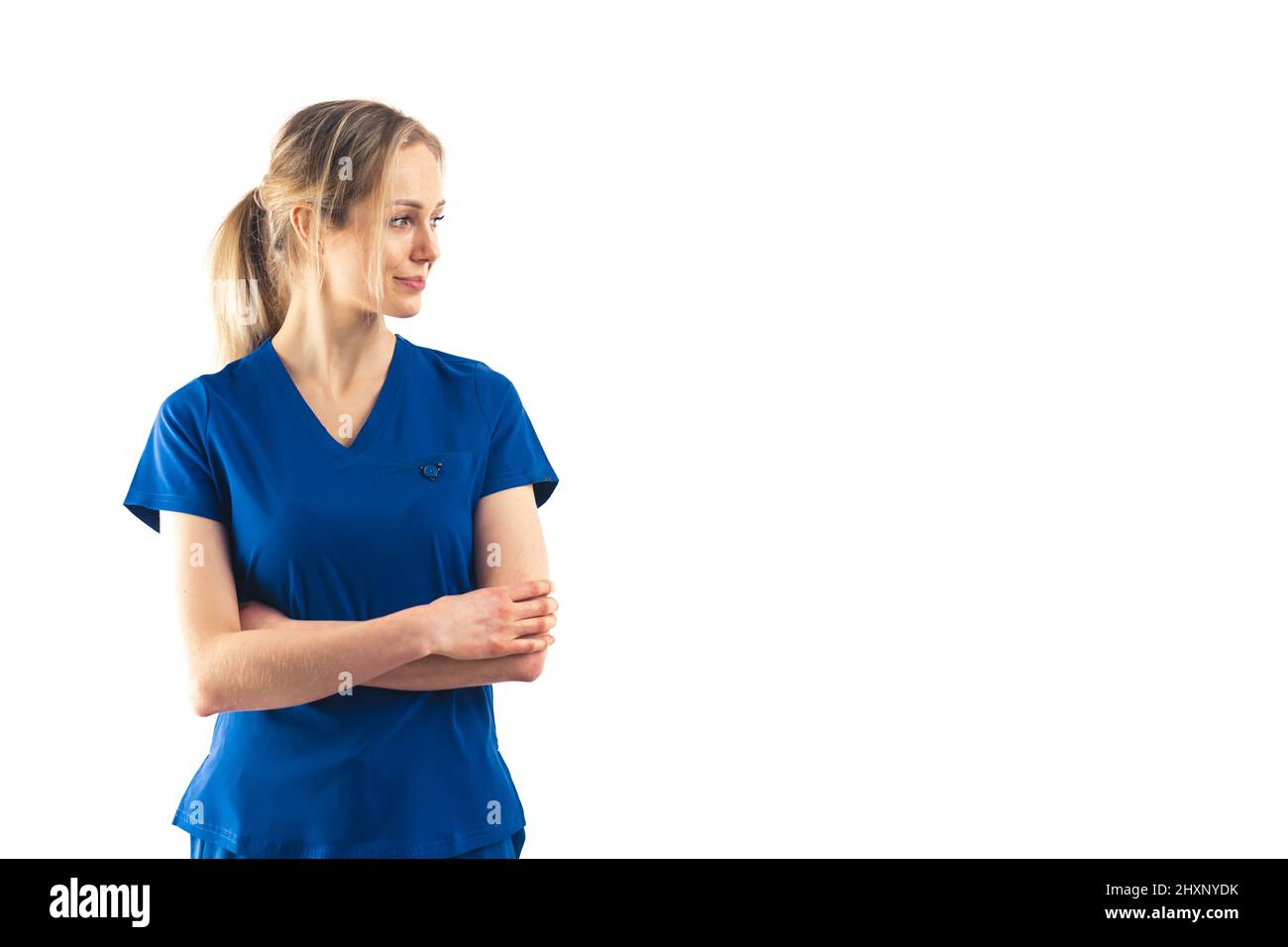 Fière infirmière caucasienne portant un uniforme bleu sur fond blanc. Espace de copie prise de vue moyenne en studio. Photo de haute qualité Banque D'Images