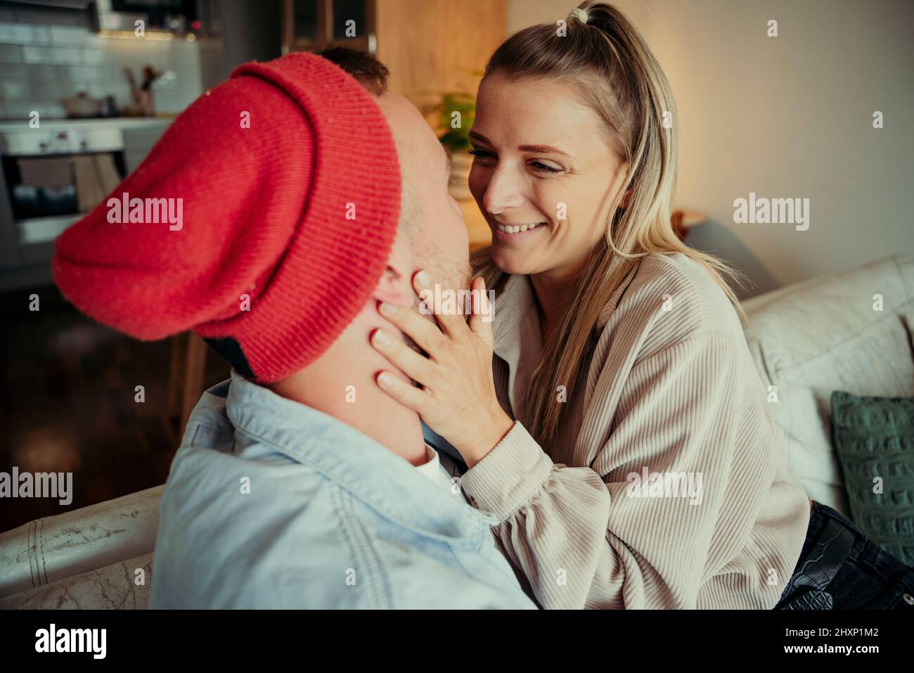 Couple affectueux caucasien assis sur un canapé embrassant Banque D'Images