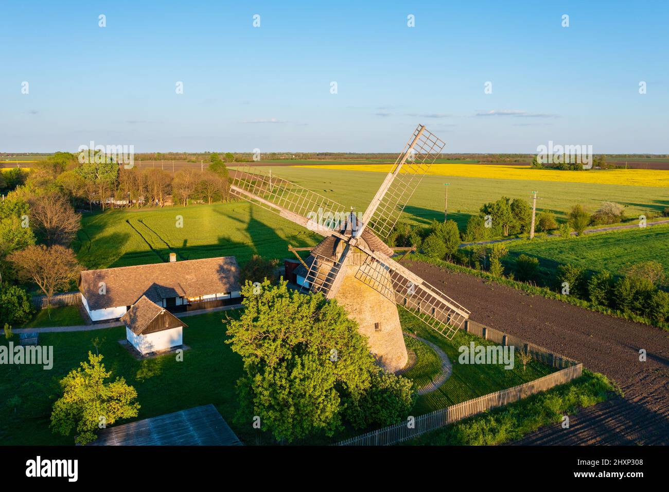 Moulin à vent traditionnel hongrois près de Hodmezovasarhely. Champ de canola à l'arrière-plan. Le nom hongrois est Papi-féle szélmalom. Banque D'Images