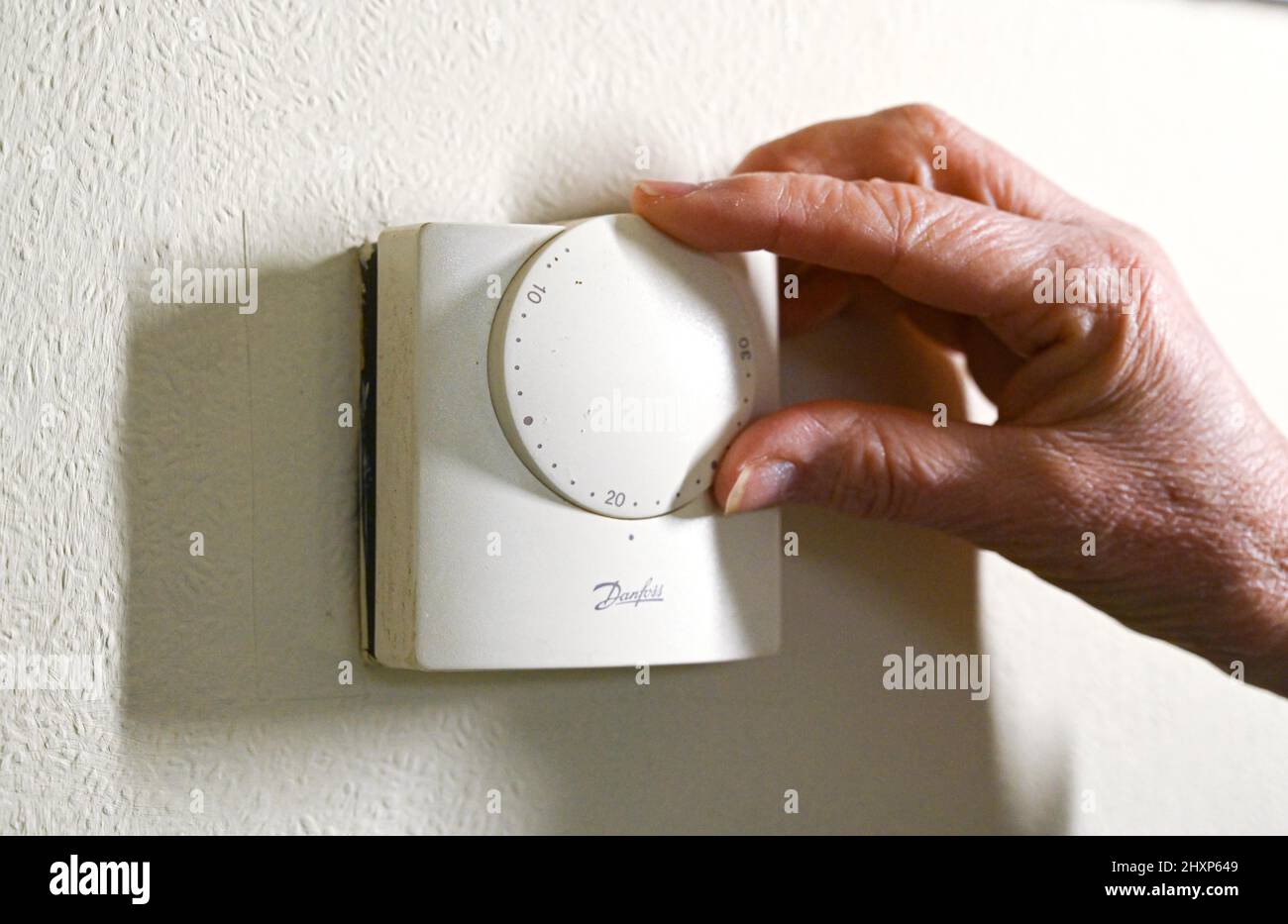 Réduire un thermostat de chauffage sur un mur de ménage britannique pour aider à économiser l'énergie à mesure que les prix augmentent de façon spectaculaire en 2022 . La réduction d'un degré de votre thermostat peut vous aider à économiser de l'argent et de l'énergie Banque D'Images