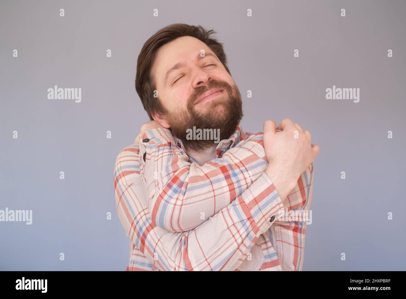 Homme caucasien avec la barbe s'embrassant heureux et positif, souriant confiant. Banque D'Images