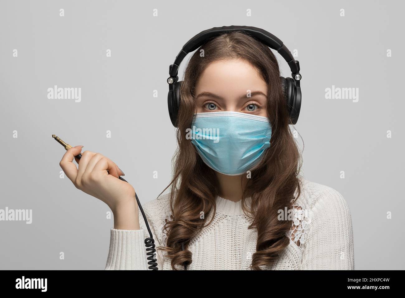 Adolescent dans un masque médical avec casque Banque D'Images