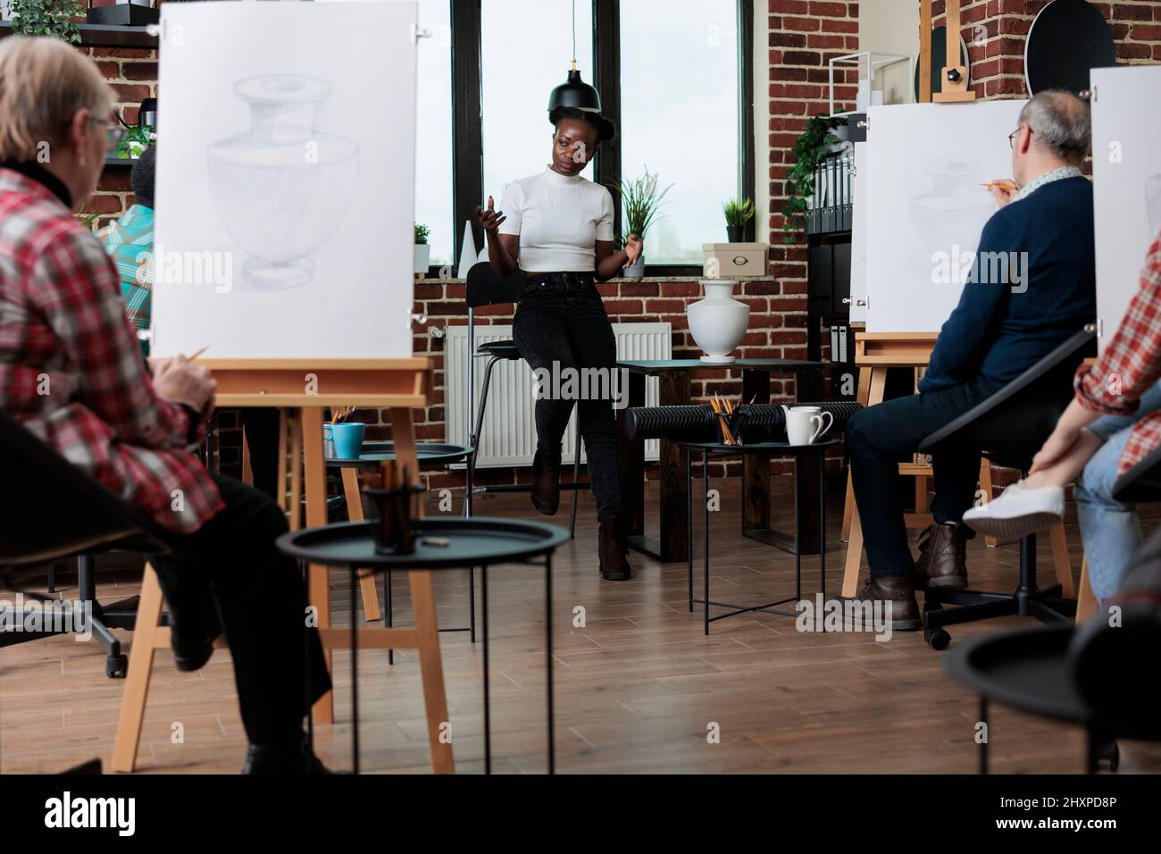 Professeur d'art enseignant aux étudiants d'art comment développer des compétences artistiques pour la croissance personnelle . Vase d'esquisse de diverses équipes sur toile blanche utilisant la technique graphique travaillant à l'illustration de dessin Banque D'Images