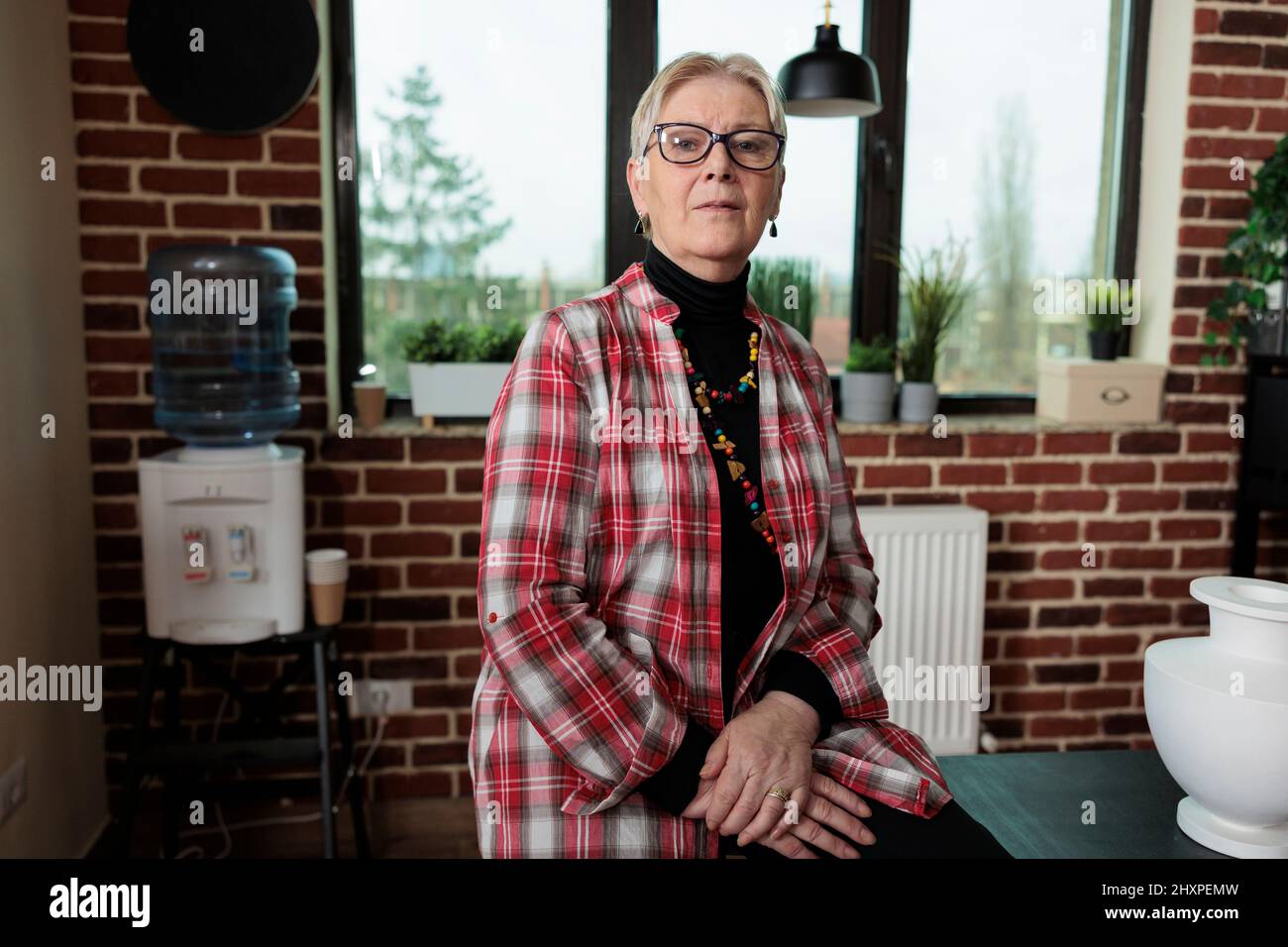 Portrait d'un enseignant principal debout sur une chaise dans un studio de créativité pendant la classe d'art. Peintre âgé enseignant la technique graphique aux étudiants travaillant à l'art créatif. Résolutions du nouvel an Banque D'Images