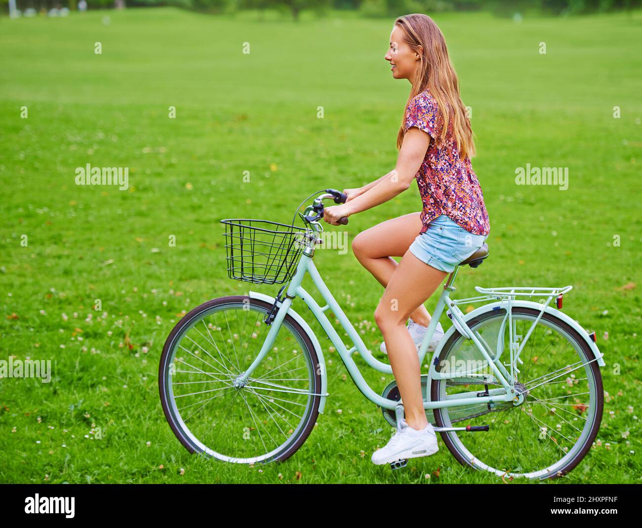 Promenade à travers la campagne. Photo d'une jeune femme en vélo dans la campagne. Banque D'Images