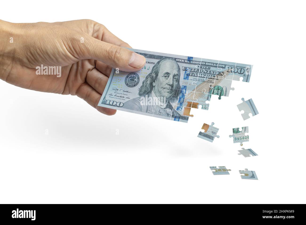 Main masculine tenant une facture de cent dollars qui se défait comme un puzzle. Concept d'inflation. Banque D'Images