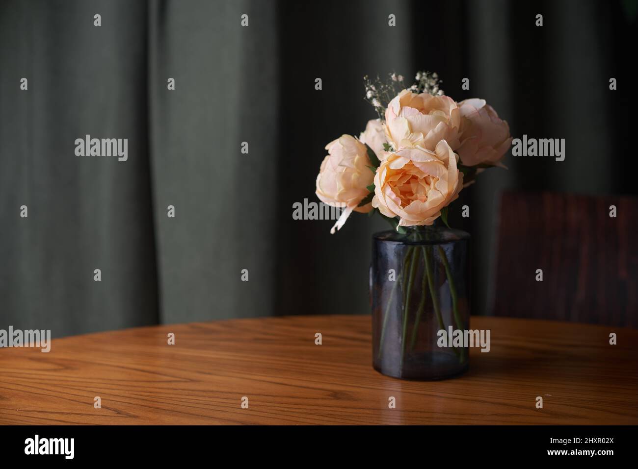 Vase avec bouquet de roses sur table en bois, espace pour le texte. Banque D'Images