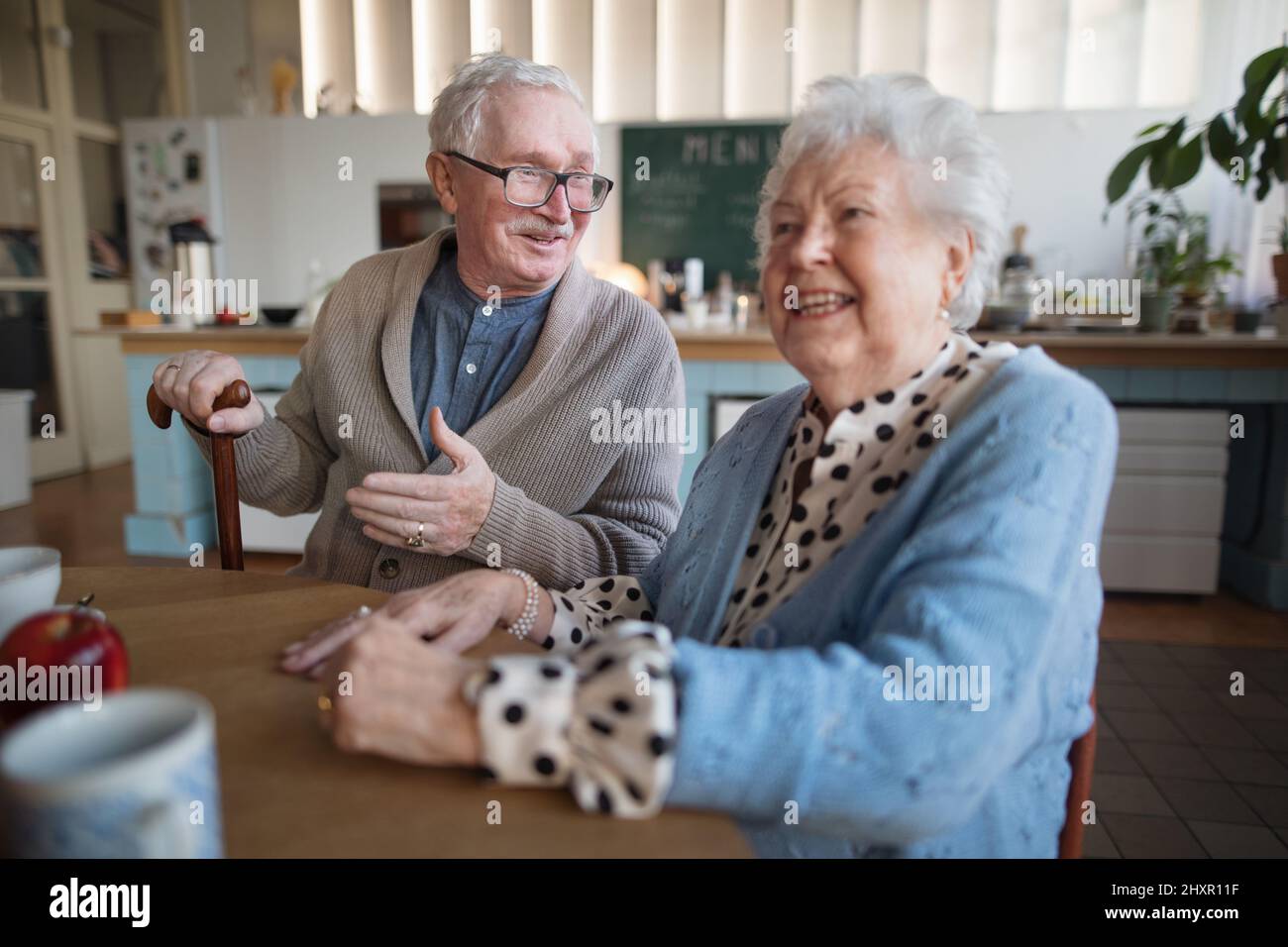 Femme et homme âgés souriant prenant le petit déjeuner dans le centre de soins à domicile. Banque D'Images