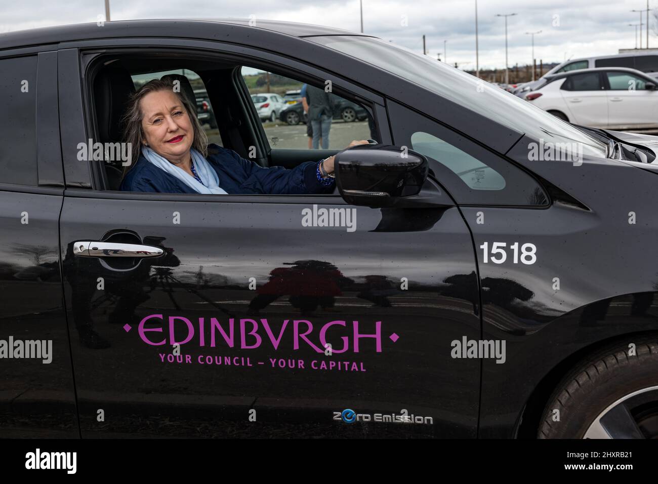 Ingliston Park & Ride, Édimbourg, Écosse, Royaume-Uni, 14 mars 2022. Ingliston Park & Ride batteries de chargement de voitures électriques : le responsable des transports et le conseiller municipal de la ville d'Édimbourg, Lesley MacInnes, voit comment les nouveaux chargeurs fonctionnent avec une voiture électrique du conseil municipal de la ville d'Édimbourg au parc et à la promenade. Quinze nouveaux chargeurs 7kwh ont été installés pour accueillir 30 véhicules électriques de plus dans le cadre du déploiement de 2,2m 000 £ du Conseil dans toute la ville. Banque D'Images