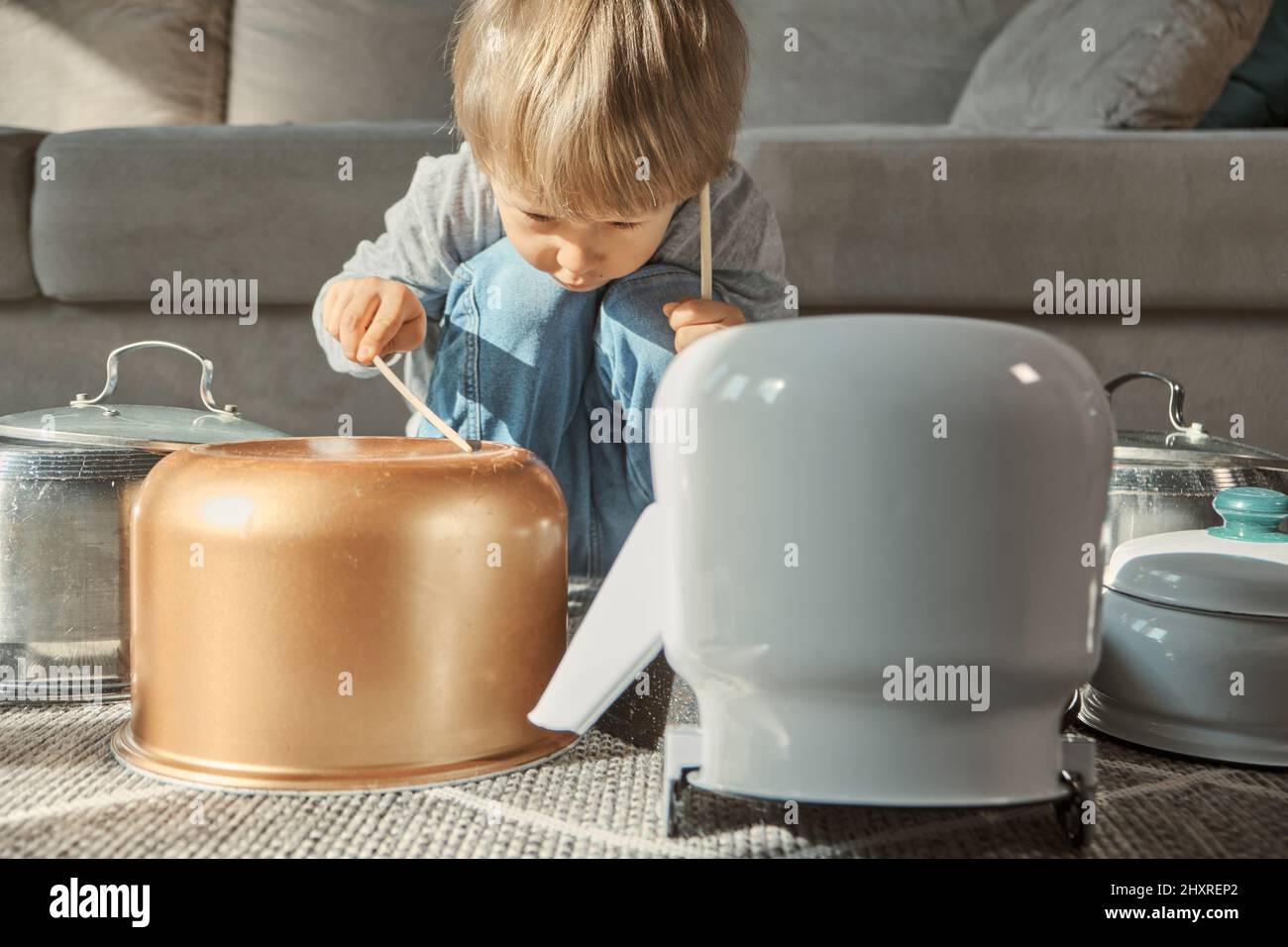 Batteur pour enfants avec tambour amusant jouant sur les casseroles de cuisine à la maison Banque D'Images