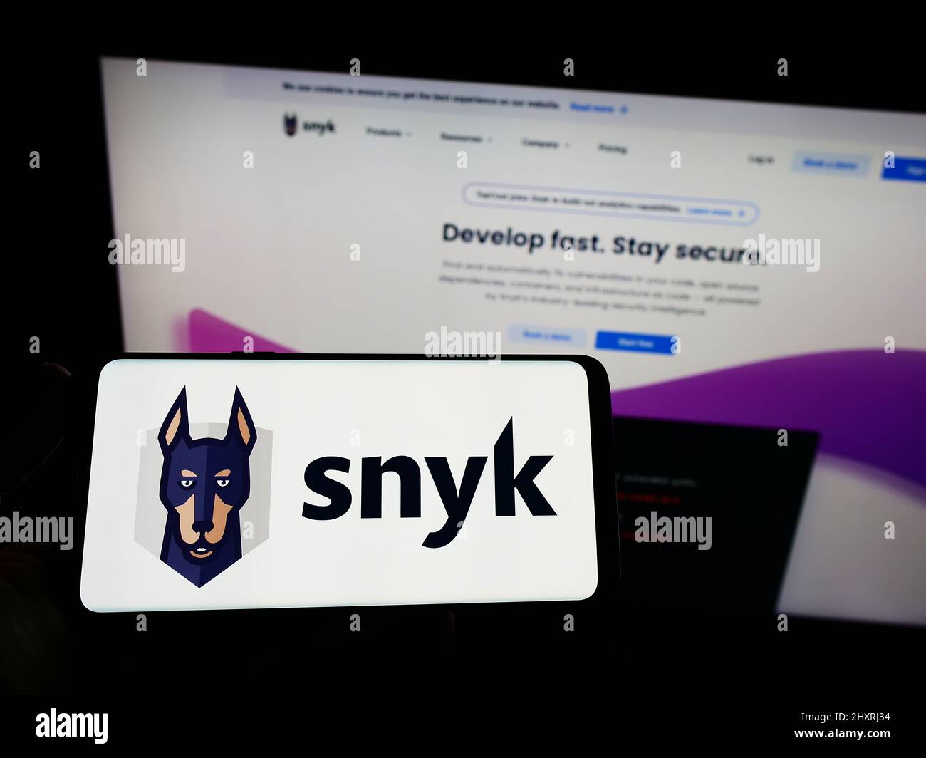 Personne tenant un smartphone avec le logo de la société américaine de cybersécurité Snyk Limited à l'écran devant le site Web. Mise au point sur l'affichage du téléphone. Banque D'Images