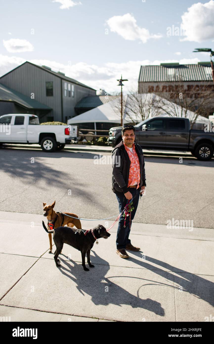 Homme mexicain d'âge moyen debout à Tin City avec des chiens en Californie Banque D'Images