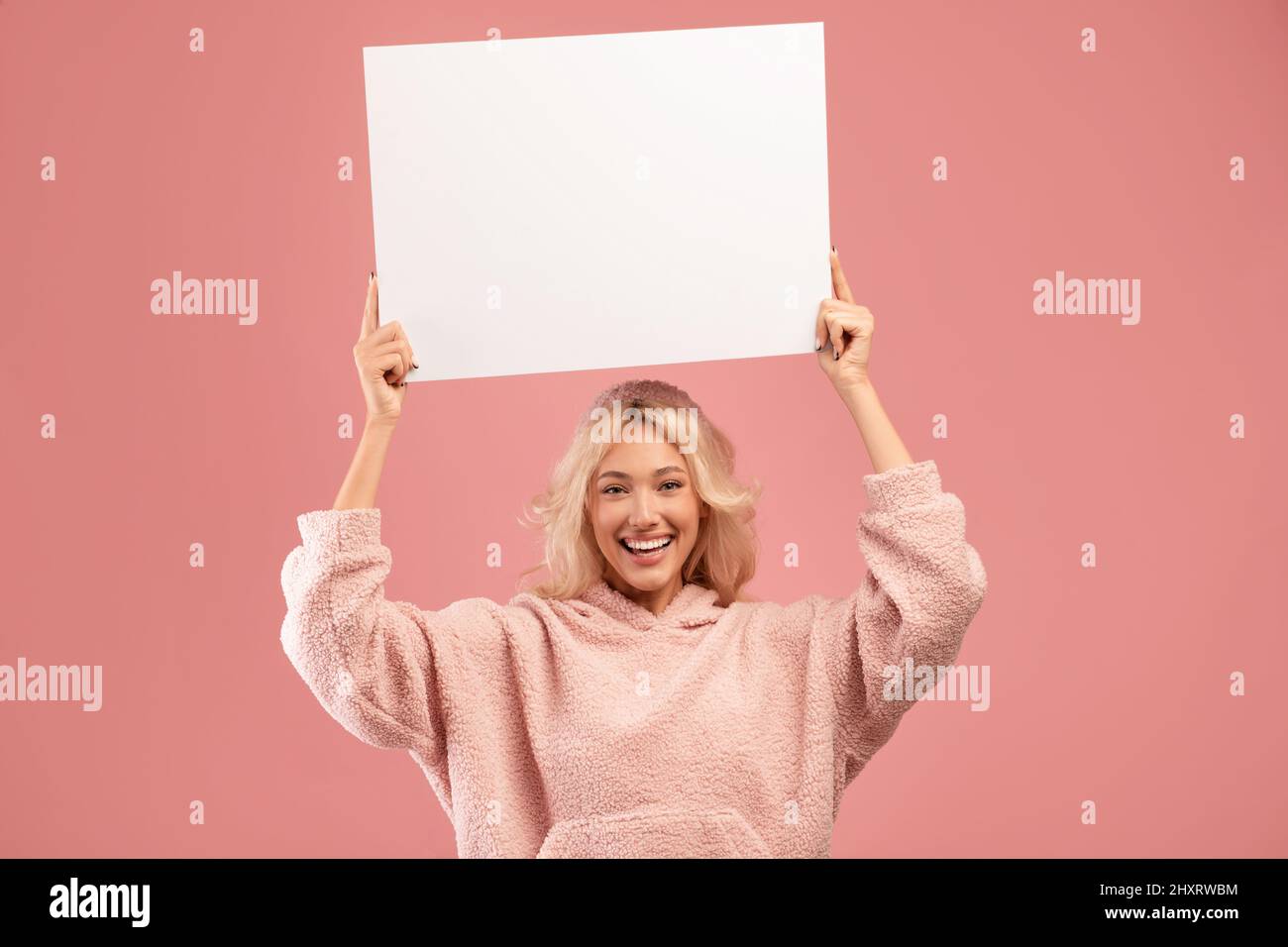 Bonne femme élégante tenant un tableau vierge pour le texte ou le design de la publicité, montrant un écriteau publicitaire vide, espace de copie Banque D'Images