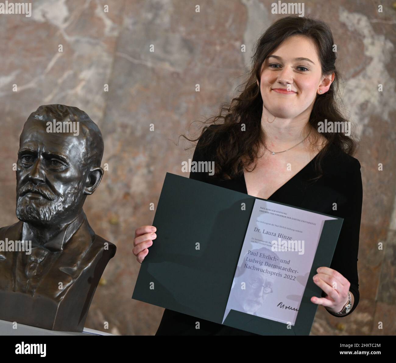 14 mars 2022, Hessen, Francfort-sur-le-main : Laura Hinze, de la faculté de médecine de Hanovre, debout à côté d'un buste de Paul Ehrlich, reçoit le prix Paul Ehrlich et Ludwig Darmstaedter Young Investigator Award 2022 dans l'église Paulskirche de Francfort. Le Prix Paul Ehrlich et Ludwig Darmstaedter est l'un des prix médicaux les plus prestigieux d'Allemagne. Le Prix du jeune chercheur est doté de 60 000 euros. Photo: Arne Dedert/dpa Banque D'Images