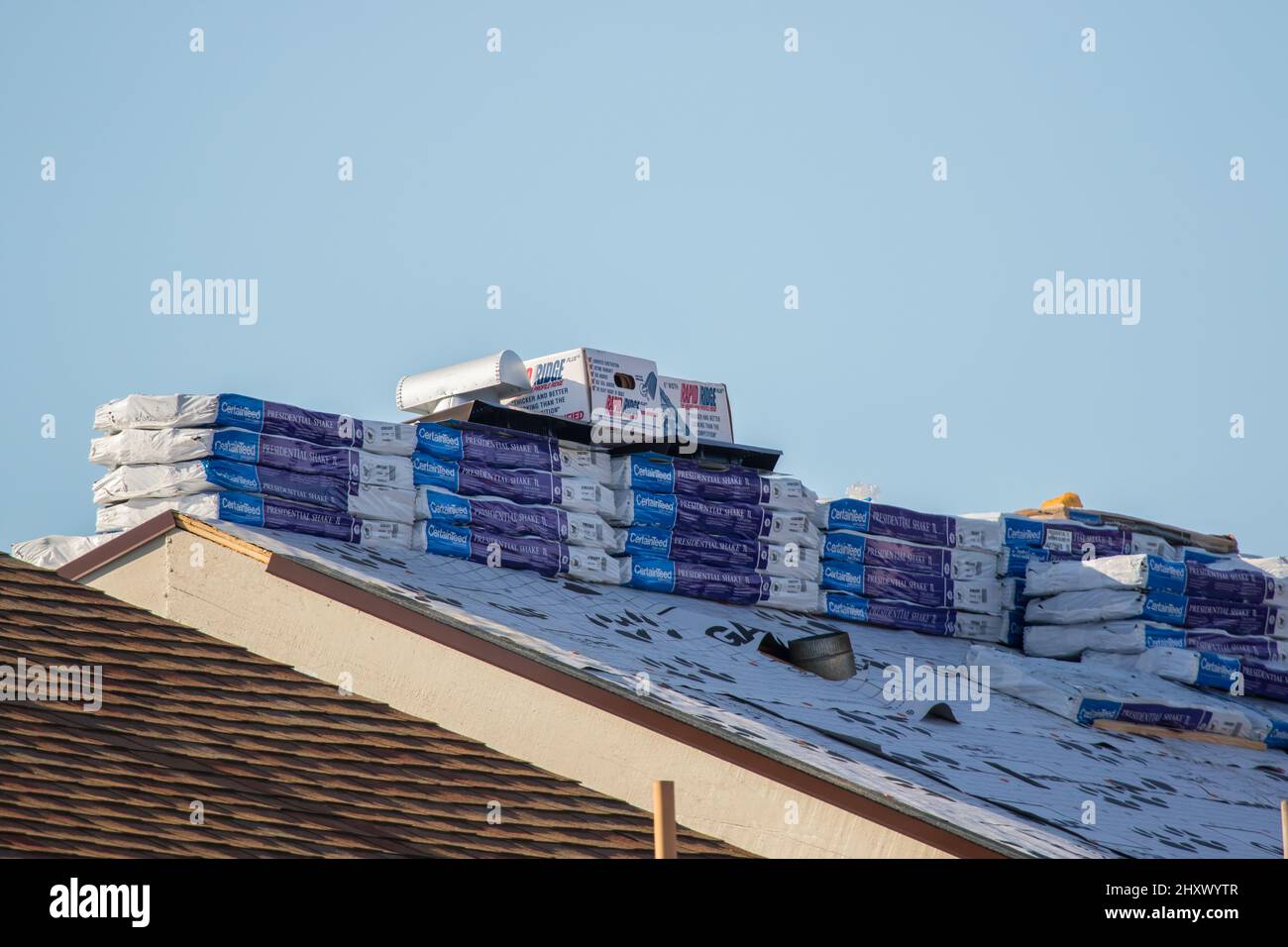 Nouveaux bardeaux de toiture certainteed, crête et solins chargés sur un toit prêt pour l'installation . En Californie ; États-Unis Banque D'Images