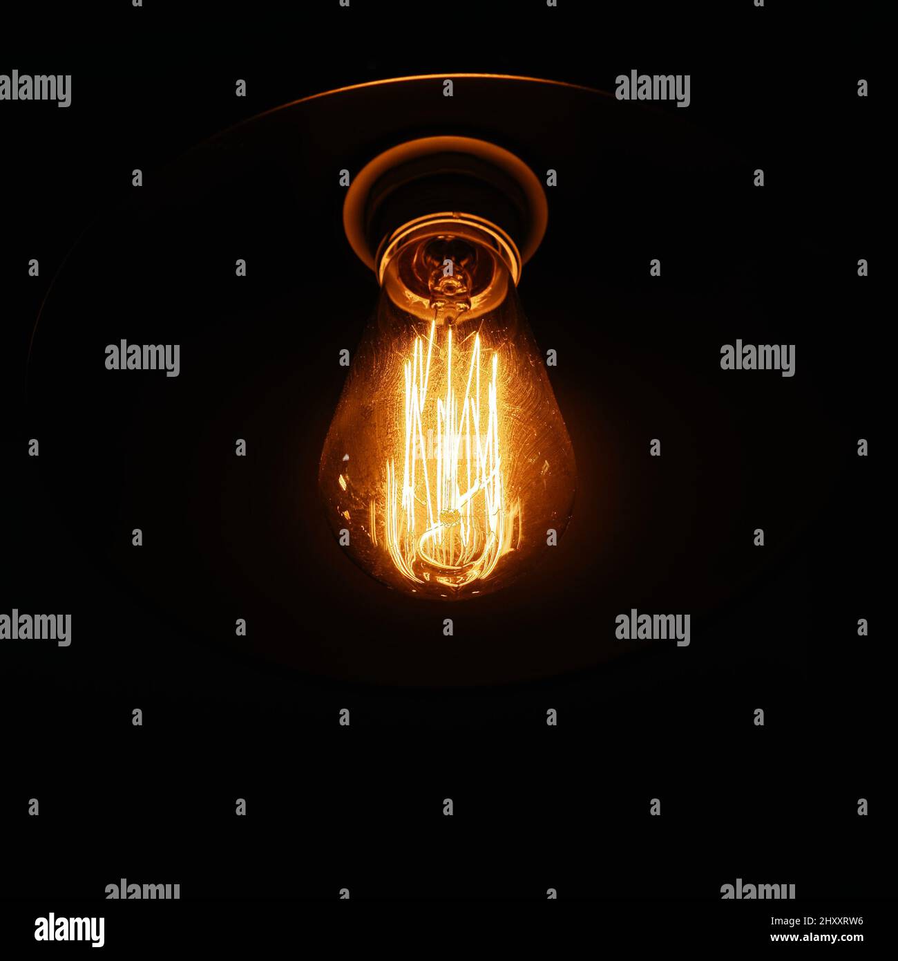 Une lampe vintage dans un flacon en verre avec un fil de tungstène à l'intérieur sur fond sombre pour un intérieur moderne. Banque D'Images