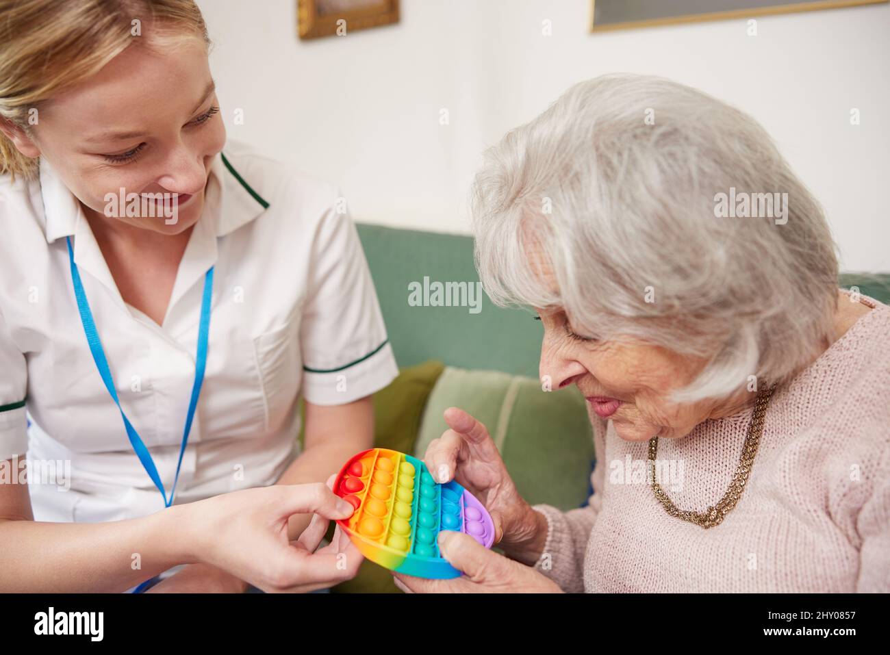Femme physiothérapeute faire appel à une femme sénior pour utiliser le jouet de violon Banque D'Images