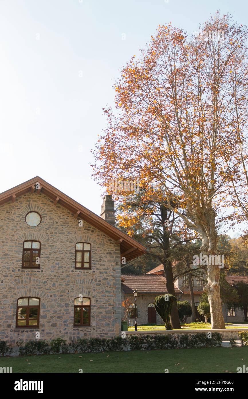 Une très belle maison immense. Toit triangulaire. Maison en pierre en automne. Couleurs douces et orange. Banque D'Images