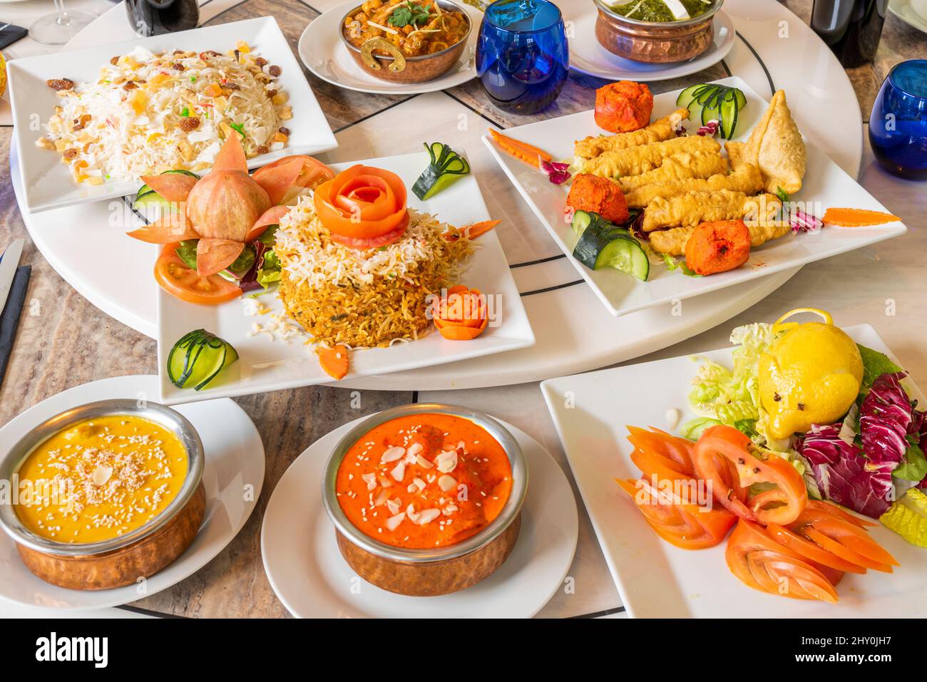 Ensemble de plats indiens avec riz basmati et cachemire, curry rouge, bhaji oignon, paneer palak, korma, tomate et laitue Banque D'Images