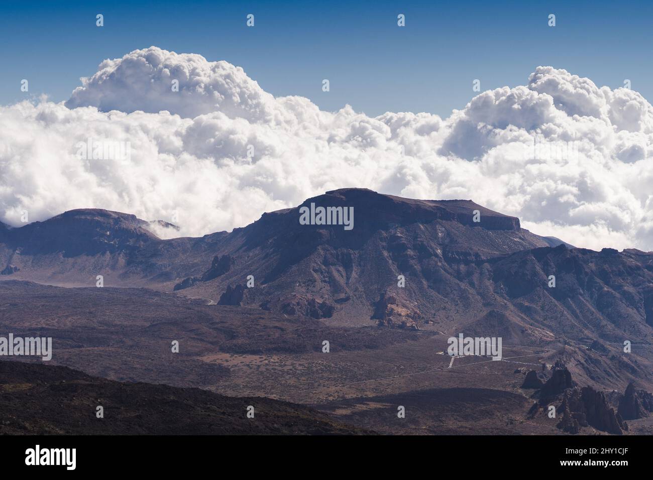 Plaine vallée volcanique entourée de hautes montagnes sous des nuages moelleux sur le ciel bleu sur l'île de Ténérife Banque D'Images