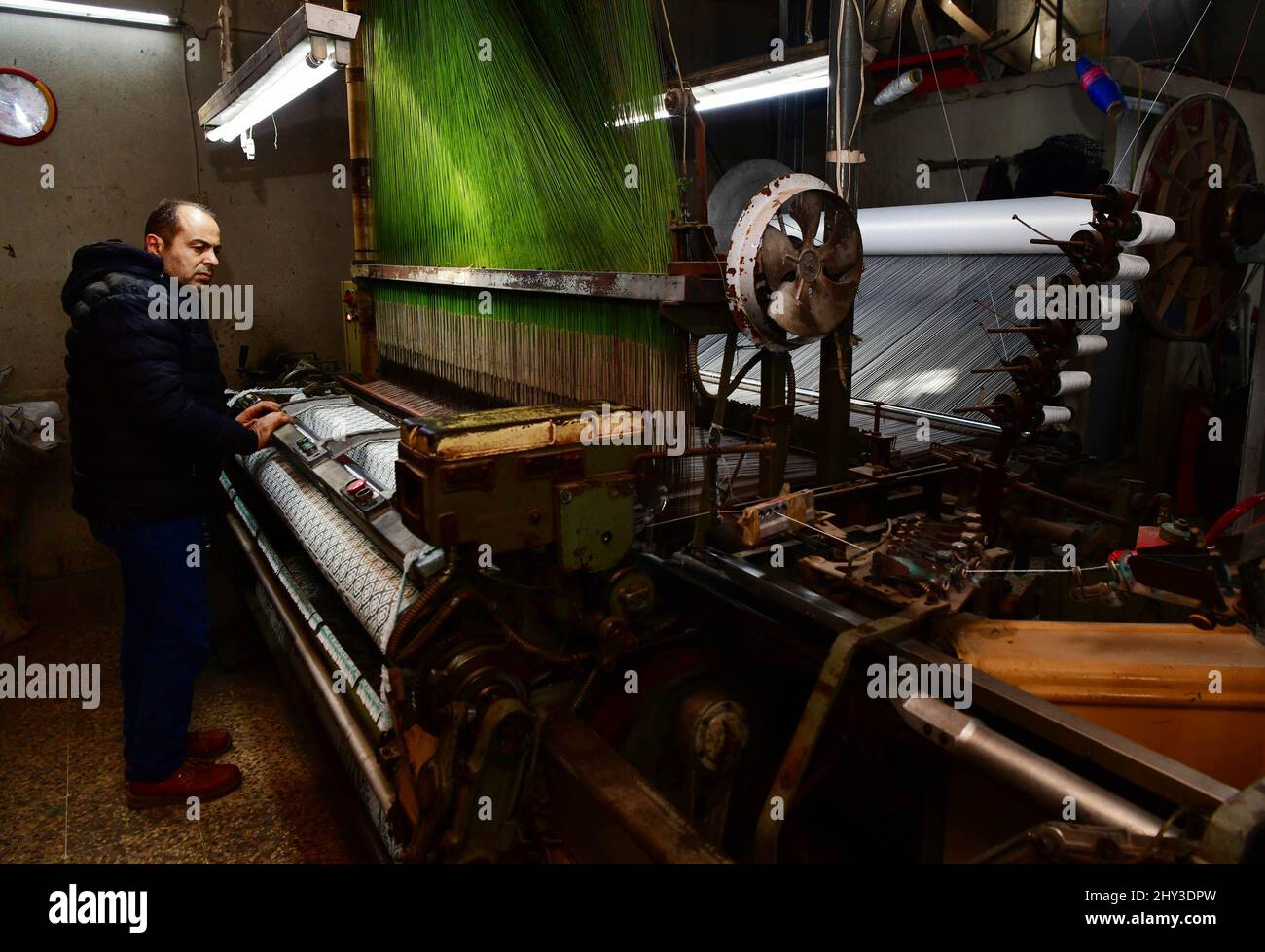 Alep. 7th mars 2022. Un homme syrien travaille dans un atelier textile à la ville industrielle d'Al-Qatirji, dans la ville d'Alep, au nord de la Syrie, le 7 mars 2022. Alors que la crise syrienne entre dans ses 12th années, les sanctions américaines et occidentales restent un obstacle majeur au retour d'une vie normale dans le pays. Les sanctions économiques, en particulier, ont paralysé la plupart des usines du pays déchiré par la guerre. Crédit: Ammar Safarjalani/Xinhua/Alamy Live News Banque D'Images