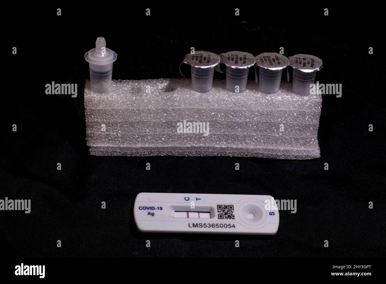 Test de débit latéral positif Covid 19 / test de coronavirus d'antigène de débit latéral rapide sur fond noir montrant les deux barres sur la bandelette de test Banque D'Images