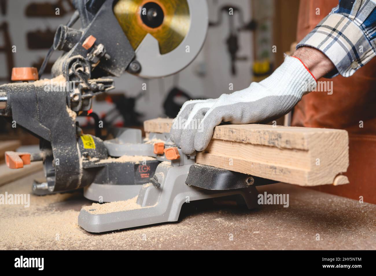 Menuisier à l'aide d'une scie circulaire électrique, coupant un morceau de bois. Photo de haute qualité. Banque D'Images