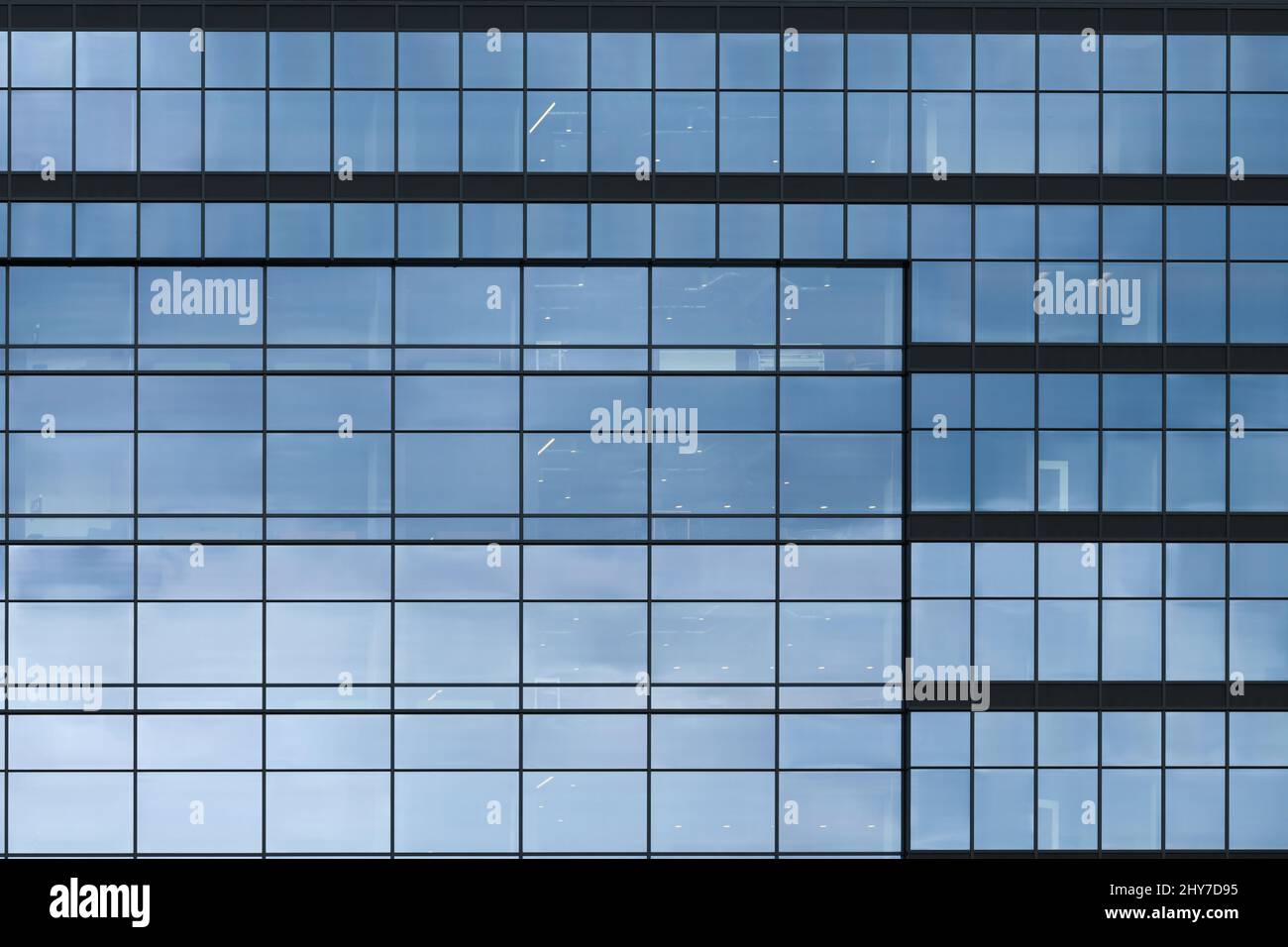 Bellevue, WA, USA - 13 mars 2022; immeuble de bureaux moderne avec façade en verre reflétant le ciel bleu gris dans une série de motifs répétés de carrés Banque D'Images